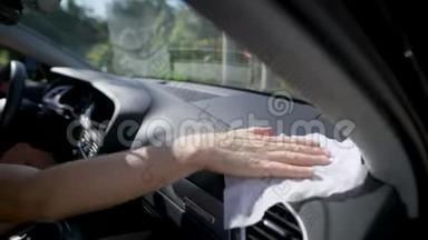 男士用湿餐巾纸将汽车清洁控制面板握在手中，<strong>详情</strong>可见